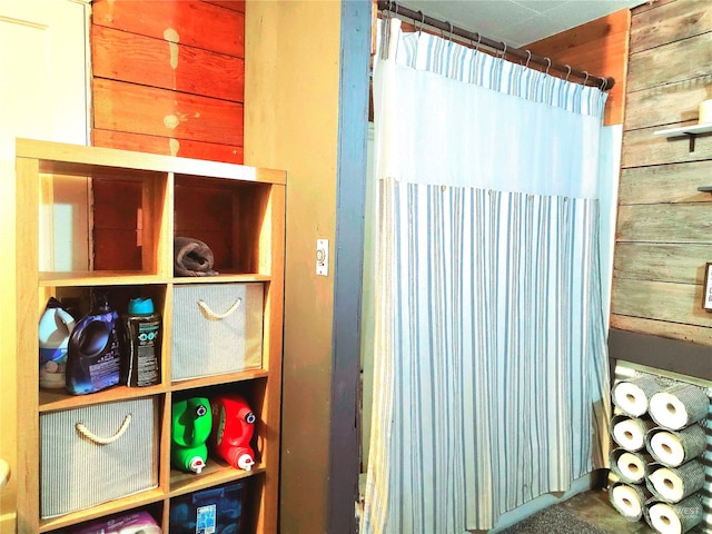 bathroom featuring wood walls and walk in shower