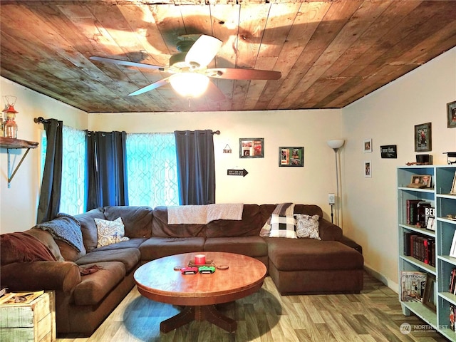 living area featuring wood finished floors, a ceiling fan, baseboards, and wooden ceiling