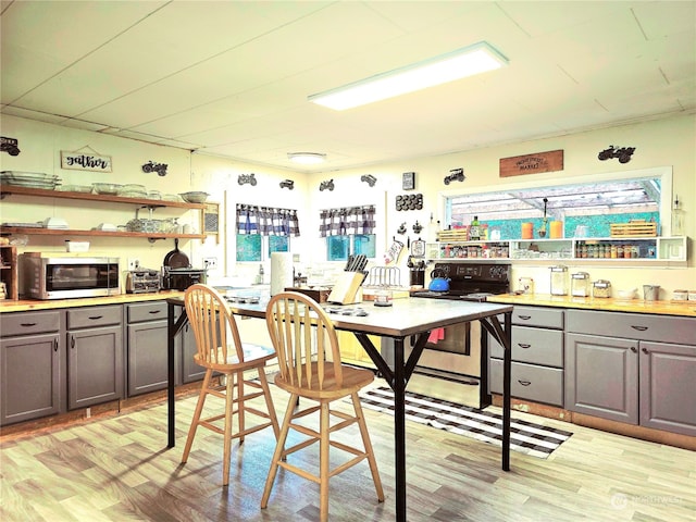 kitchen featuring light wood-type flooring, gray cabinetry, and electric range oven