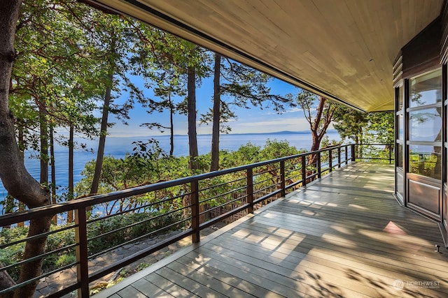 wooden terrace featuring a water view