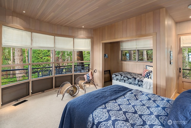 bedroom with wood walls, wood ceiling, and carpet flooring