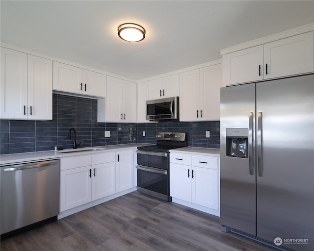 kitchen featuring white cabinets, sink, backsplash, appliances with stainless steel finishes, and dark hardwood / wood-style floors