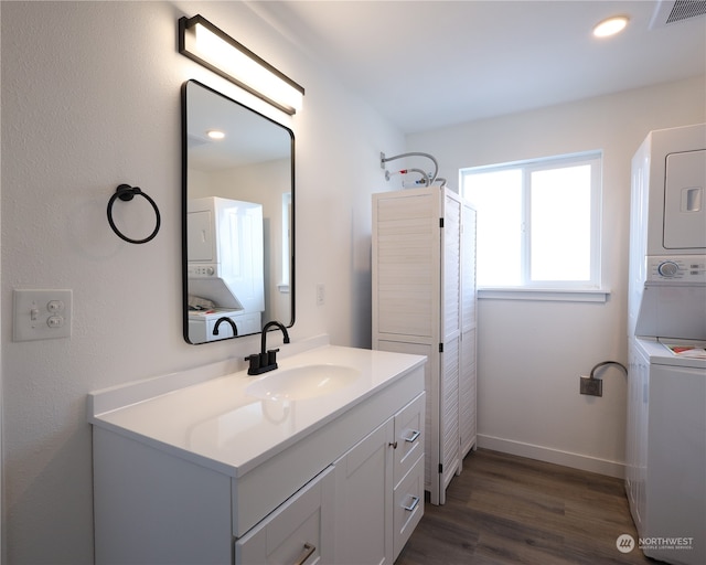 bathroom featuring wood-type flooring, vanity, and stacked washer and dryer