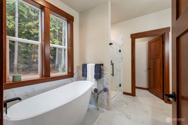 bathroom featuring separate shower and tub and a healthy amount of sunlight