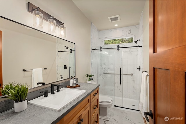 bathroom featuring vanity, toilet, and a shower with shower door