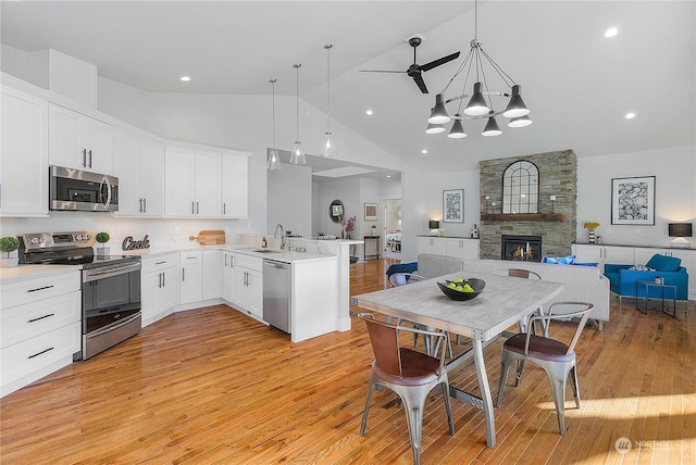 1690 Lilypad Pl E, Port Orchard, WA 98366 - kitchen with stainless steel appliances, a peninsula, open floor plan, a sink, and high vaulted ceiling