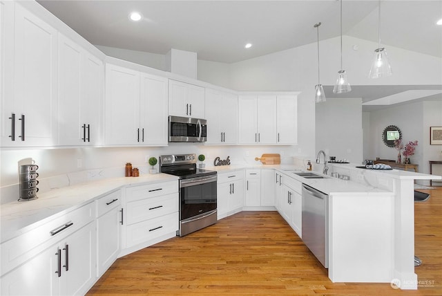 1690 Lilypad Pl E, Port Orchard, WA 98366 - kitchen featuring appliances with stainless steel finishes, a sink, a peninsula, white cabinetry, and light wood-type flooring