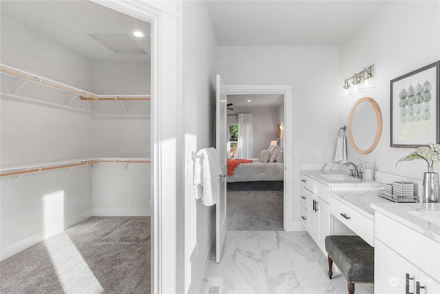 1690 Lilypad Pl E, Port Orchard, WA 98366 - ensuite bathroom with vanity, baseboards, a walk in closet, and marble finish floors
