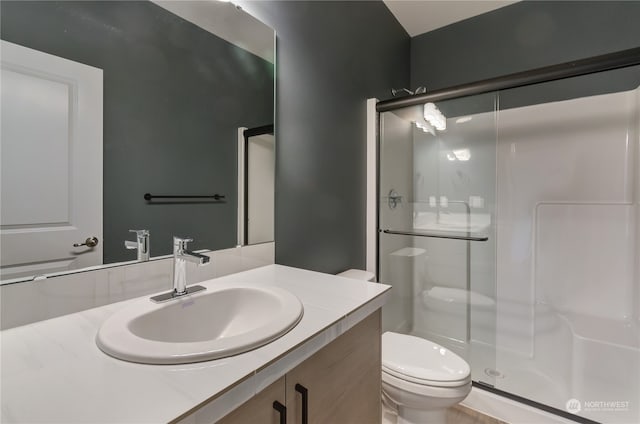 bathroom featuring walk in shower, vanity, and toilet