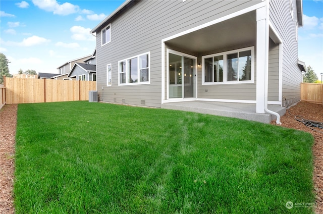 back of property with a lawn and a patio area