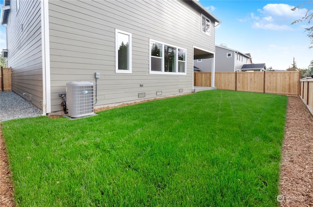 rear view of house featuring a yard and central AC unit