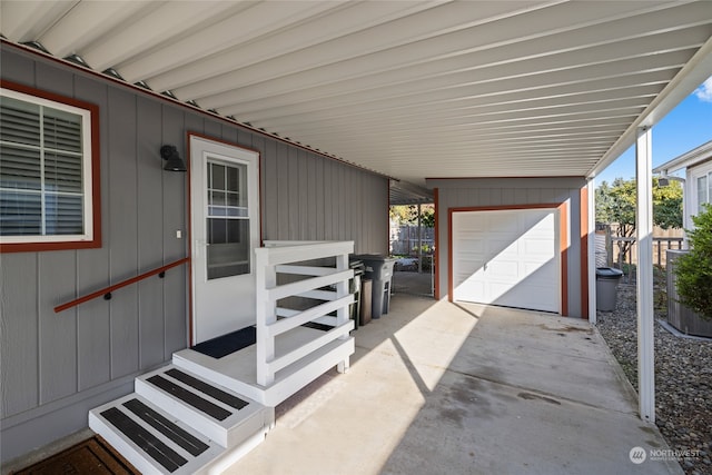 view of patio / terrace with a garage and an outbuilding