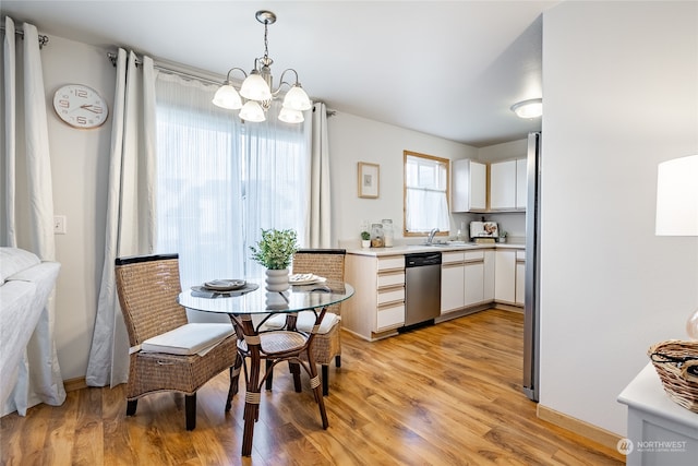 dining room featuring an inviting chandelier, sink, and light hardwood / wood-style flooring