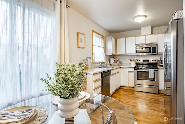 4232 Wintergreen Cir Unit 160, Bellingham, WA 98226 - kitchen featuring appliances with stainless steel finishes, a sink, light wood finished floors, light countertops, and white cabinets