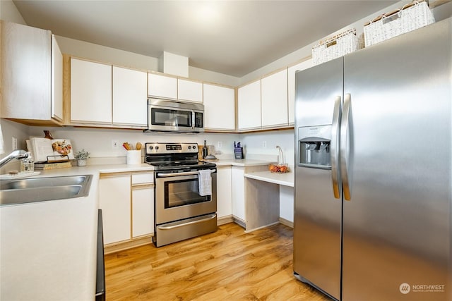 4232 Wintergreen Cir Unit 160, Bellingham, WA 98226 - kitchen with stainless steel appliances, a sink, light wood finished floors, light countertops, and white cabinetry