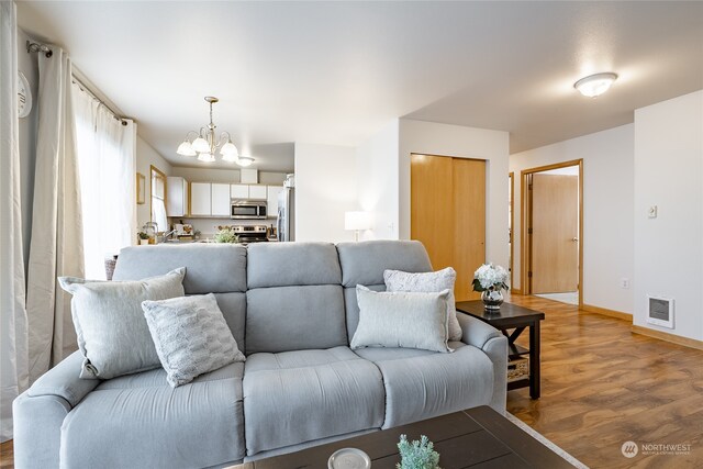 living room featuring a notable chandelier and wood-type flooring