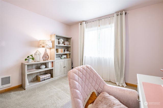 living area featuring heating unit, light carpet, and a wealth of natural light