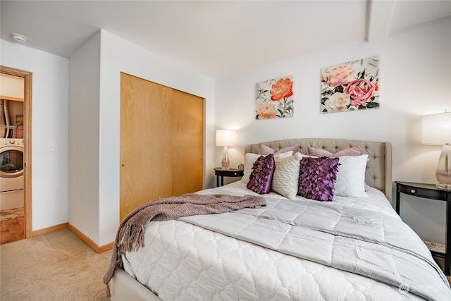 carpeted bedroom with washer / clothes dryer and a closet