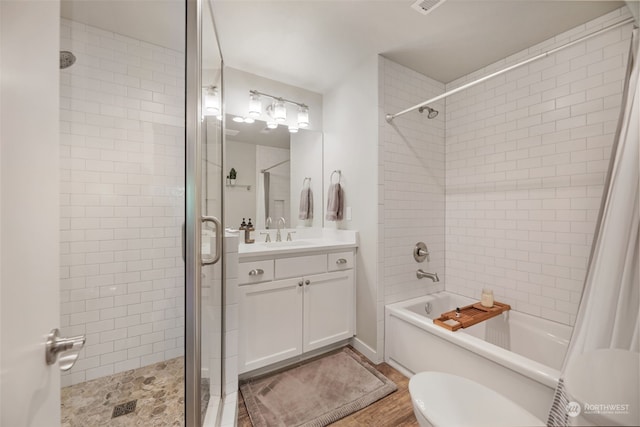 full bathroom featuring wood-type flooring, shower / bath combo, vanity, and toilet