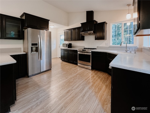 kitchen featuring a wealth of natural light, pendant lighting, lofted ceiling, and stainless steel appliances