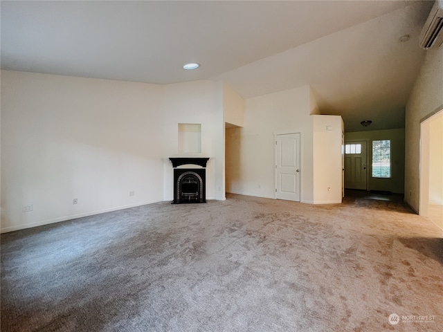 unfurnished living room featuring carpet flooring, lofted ceiling, and an AC wall unit