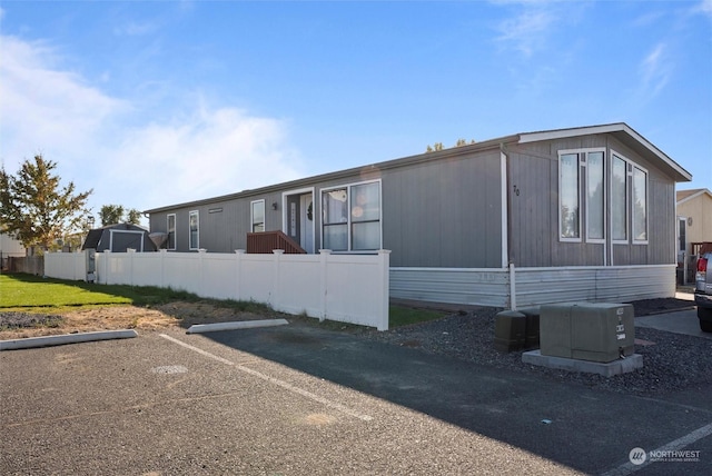 manufactured / mobile home featuring uncovered parking and fence