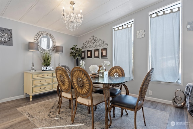 dining space with a chandelier, crown molding, and hardwood / wood-style flooring