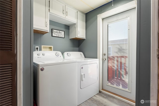 washroom with independent washer and dryer, light hardwood / wood-style flooring, and cabinets