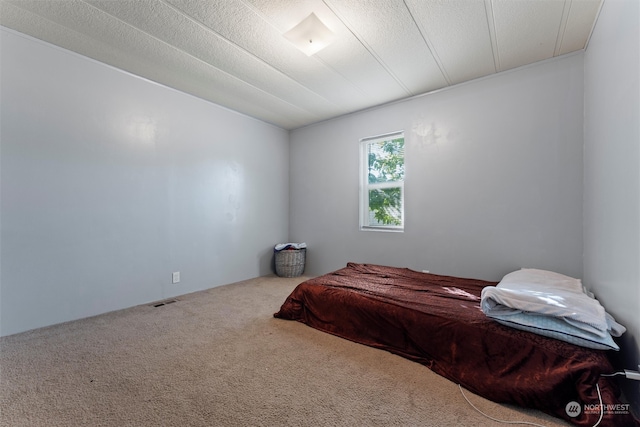 bedroom with carpet floors and a textured ceiling