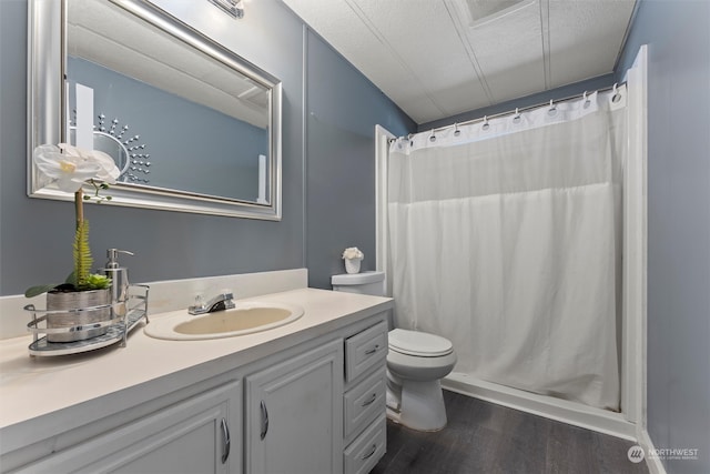 bathroom with walk in shower, vanity, hardwood / wood-style flooring, toilet, and a textured ceiling