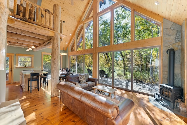 living room featuring a wood stove, high vaulted ceiling, wooden ceiling, and wood-type flooring