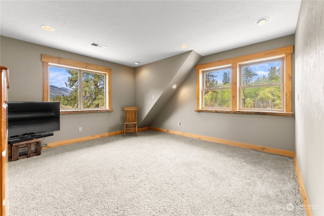 unfurnished living room featuring carpet flooring and a healthy amount of sunlight