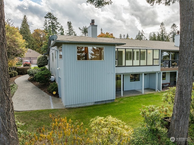 rear view of house featuring a lawn