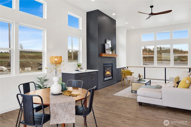 8721 Semiahmoo Dr, Blaine, WA 98230 - living room featuring a glass covered fireplace, plenty of natural light, wood finished floors, and a towering ceiling