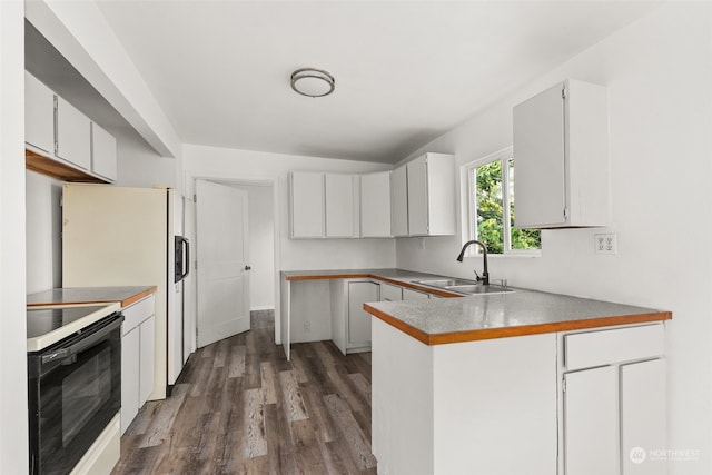 kitchen featuring kitchen peninsula, sink, black range, white cabinetry, and dark hardwood / wood-style flooring