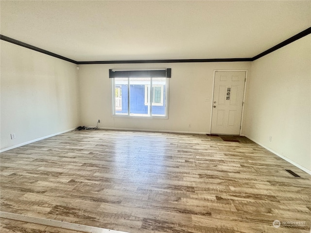 unfurnished room featuring crown molding, light hardwood / wood-style floors, and a textured ceiling