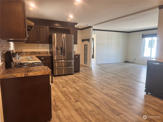 kitchen with dark brown cabinetry, sink, stainless steel fridge, light wood-type flooring, and ornamental molding