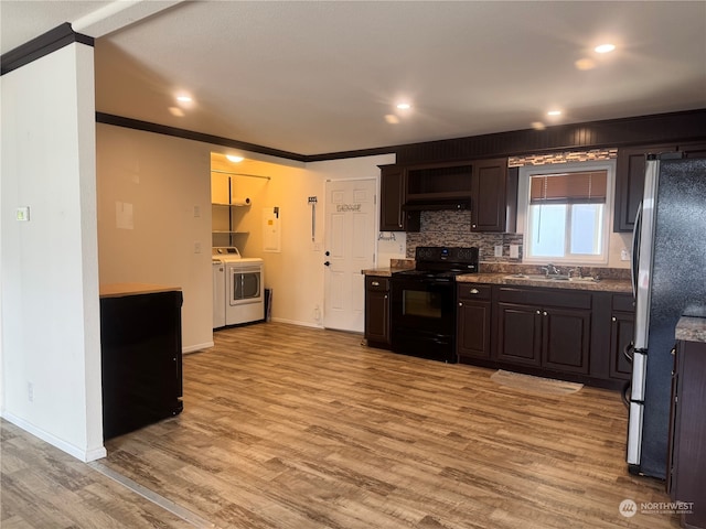 kitchen with sink, black electric range, stainless steel fridge, crown molding, and dark brown cabinets