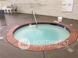 view of swimming pool featuring a community hot tub