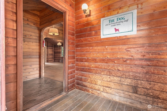 corridor featuring wood walls