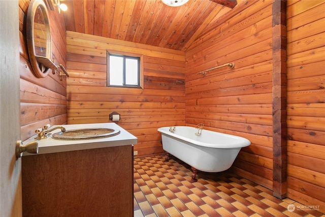 bathroom with wood walls, a tub to relax in, wood ceiling, vaulted ceiling, and vanity