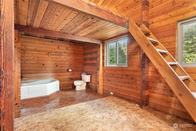 bathroom featuring wood walls, toilet, wooden ceiling, beam ceiling, and a tub