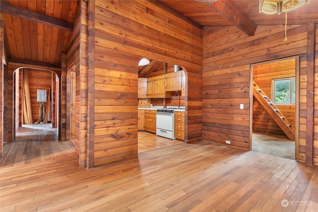 kitchen featuring wood walls, lofted ceiling with beams, wooden ceiling, white range, and light hardwood / wood-style floors