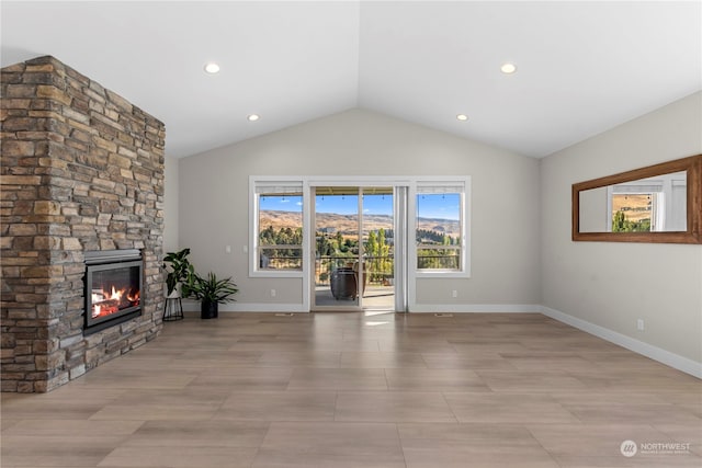 unfurnished living room with a stone fireplace and vaulted ceiling