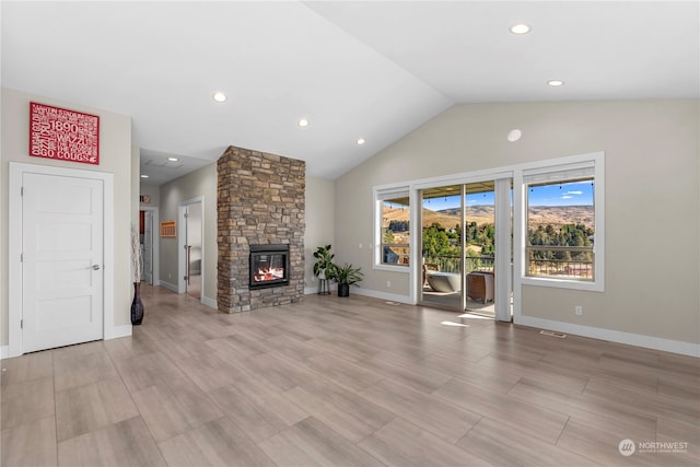 unfurnished living room featuring high vaulted ceiling and a stone fireplace