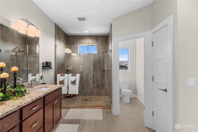 bathroom with a shower with door, vanity, and toilet