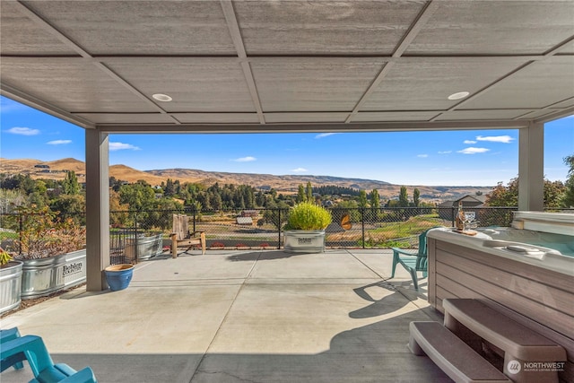 view of patio / terrace featuring a mountain view and a hot tub