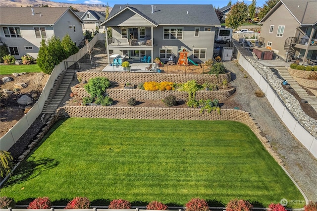 back of house with a balcony and a lawn