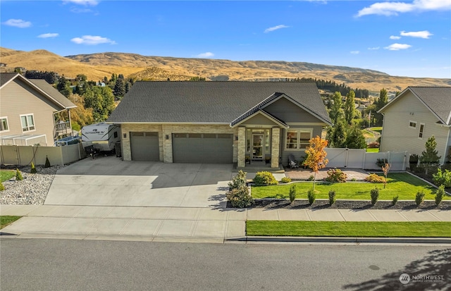 view of front of home with a mountain view, a garage, and a front yard