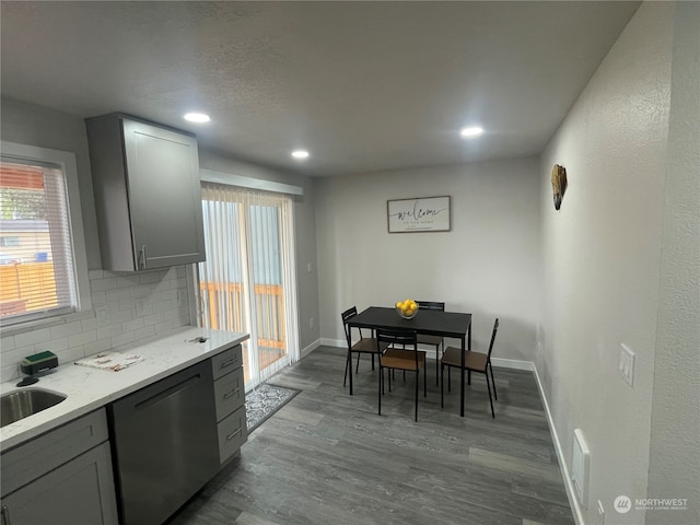 kitchen with dishwasher, gray cabinets, tasteful backsplash, and hardwood / wood-style flooring